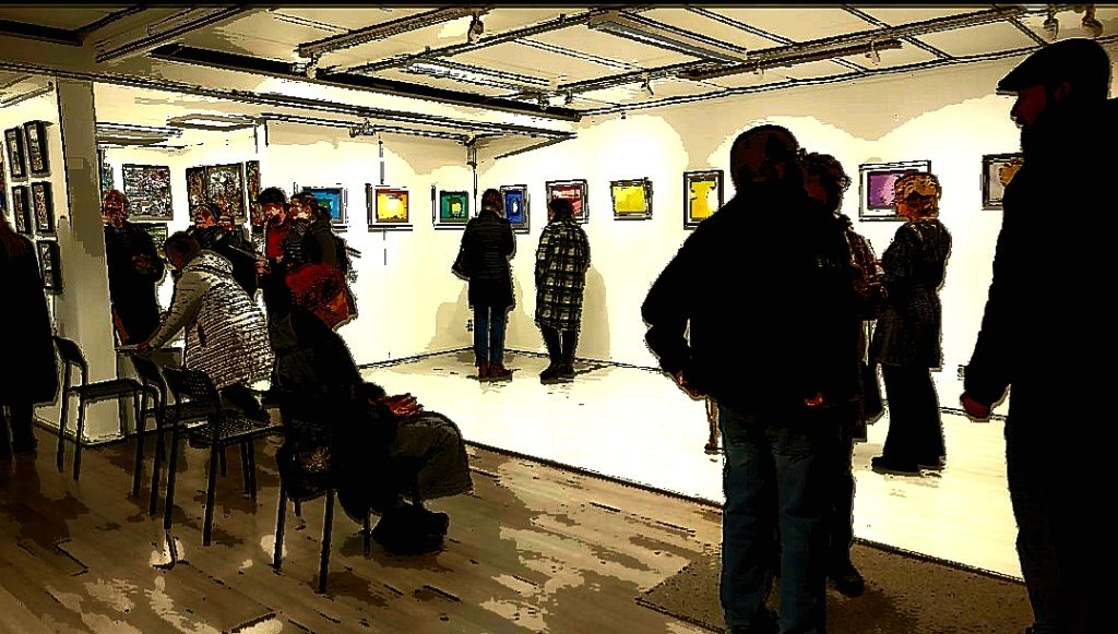 Taiteilijatapaaminen galleriassa: ihmisiä katselemassa teoksia ja istumassa tuoleilla.